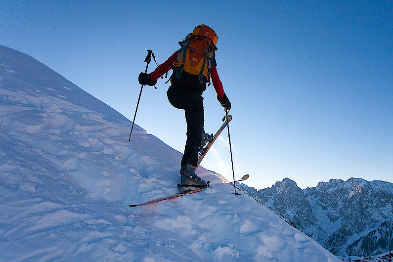 Basis ist eine stabile Ausgangsposition. Beide Ski stehen parallel in der Aufstiegsspur, solide auf dem Schnee aufliegend (bei unebenem Untergrund fest aufstampfen) und möglichst flach zur Falllinie.