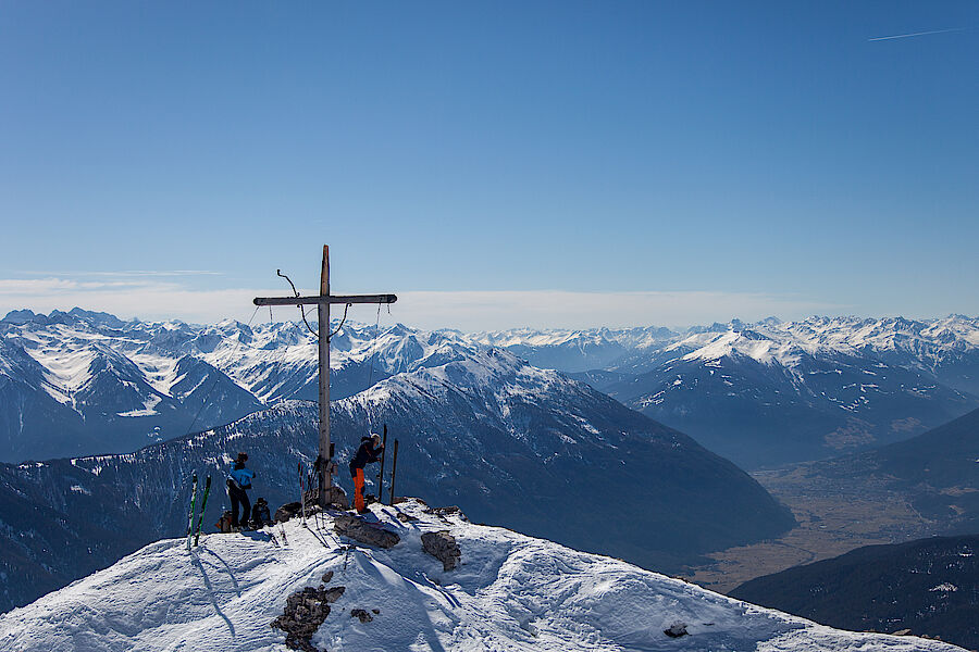 Tiefblick vom Gipfel auf das frühlingshafte Inntal