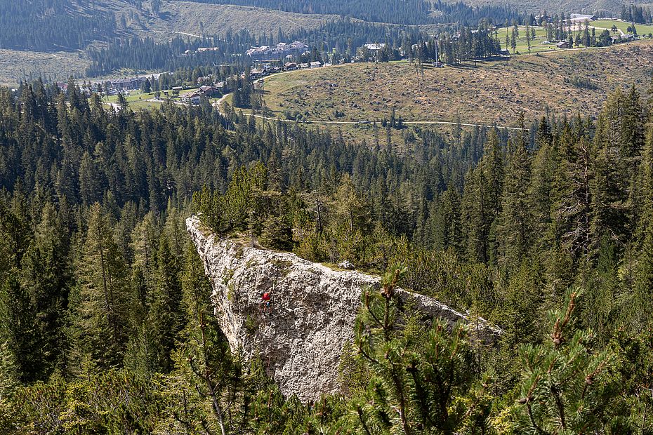 Das Kluan Rotwandl spitzt aus den Bäumen über dem Ort Karersee hervor Das Kluan Rotwandl spitzt aus den Bäumen über dem Ort Karersee hervor